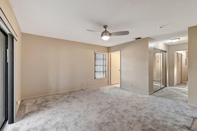 empty room with ceiling fan and light colored carpet