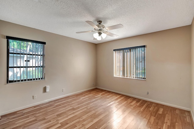 empty room with ceiling fan, light hardwood / wood-style floors, and a textured ceiling