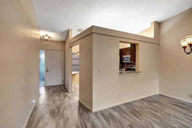 foyer entrance featuring a textured ceiling, hardwood / wood-style flooring, and high vaulted ceiling