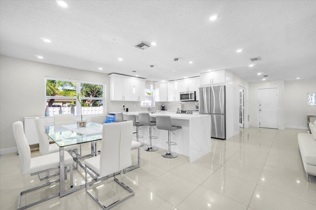 dining room featuring a textured ceiling and light tile patterned flooring