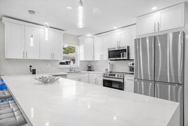 kitchen with a kitchen bar, white cabinets, stainless steel appliances, and decorative light fixtures