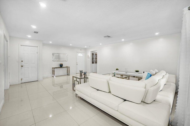 living room featuring light tile patterned flooring and a textured ceiling