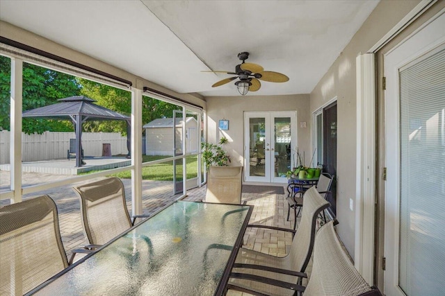 sunroom / solarium with french doors, ceiling fan, and a healthy amount of sunlight