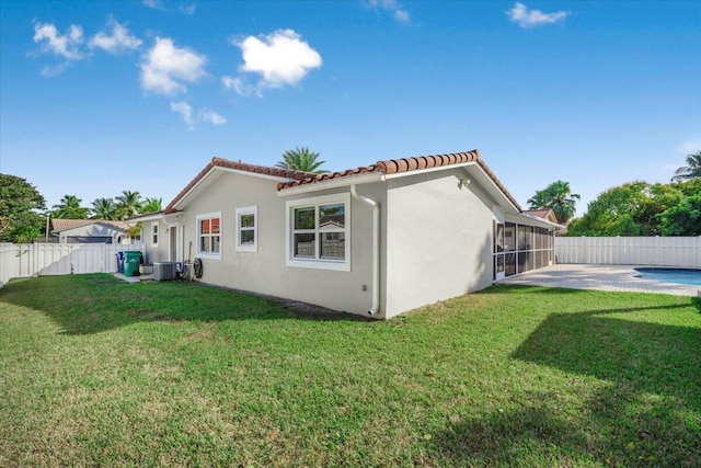 rear view of house with a patio area, a yard, and central air condition unit