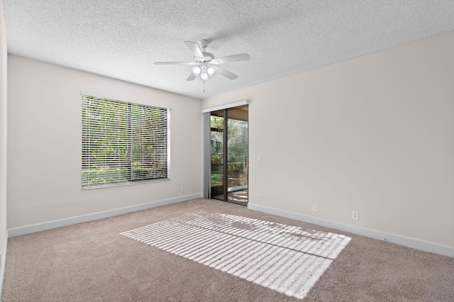 carpeted spare room with a textured ceiling and ceiling fan