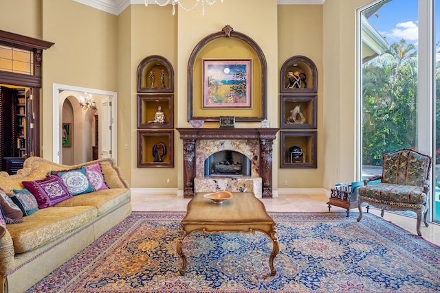 living room with built in features, ornamental molding, and a notable chandelier