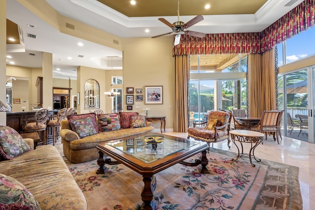 living room featuring a raised ceiling, ceiling fan with notable chandelier, a high ceiling, and ornamental molding