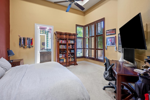 carpeted bedroom featuring ceiling fan and ensuite bath