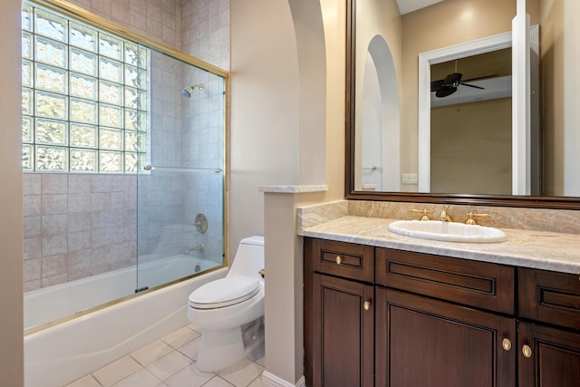 full bathroom featuring vanity, tile patterned floors, combined bath / shower with glass door, ceiling fan, and toilet