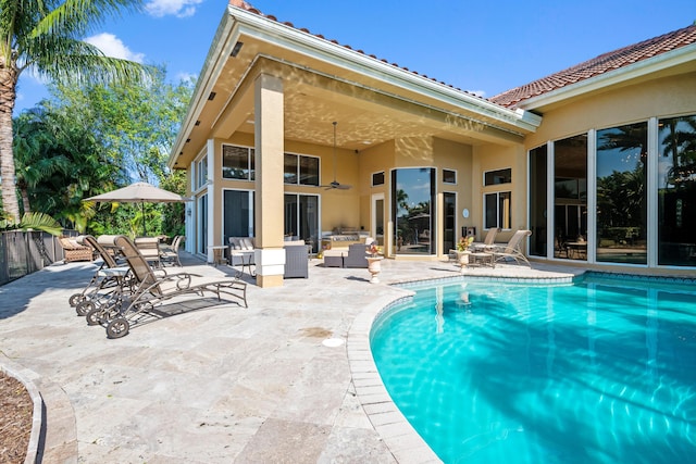 view of pool with an outdoor living space, a patio, and ceiling fan