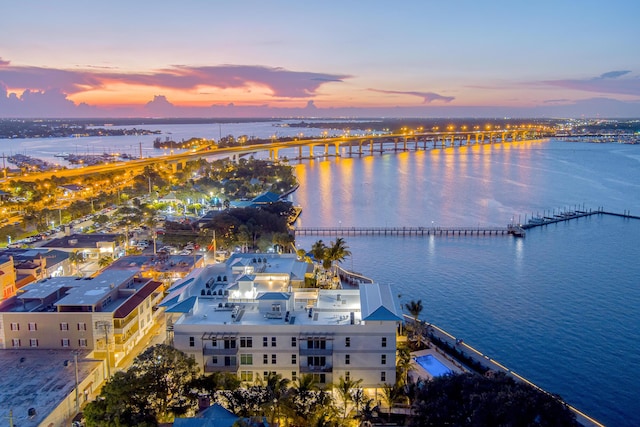 aerial view at dusk featuring a water view