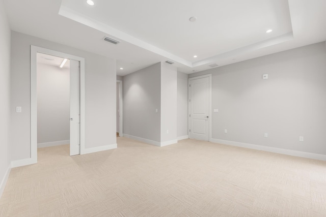 carpeted empty room with a tray ceiling