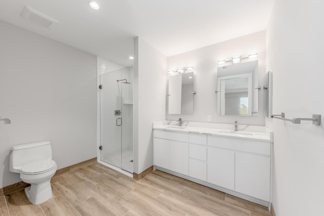 bathroom with vanity, toilet, and a shower with shower door