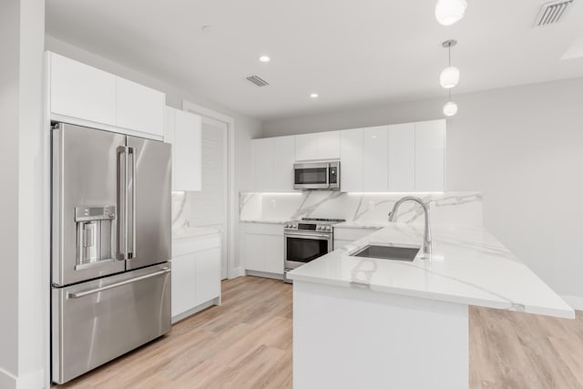 kitchen with pendant lighting, white cabinetry, sink, and appliances with stainless steel finishes