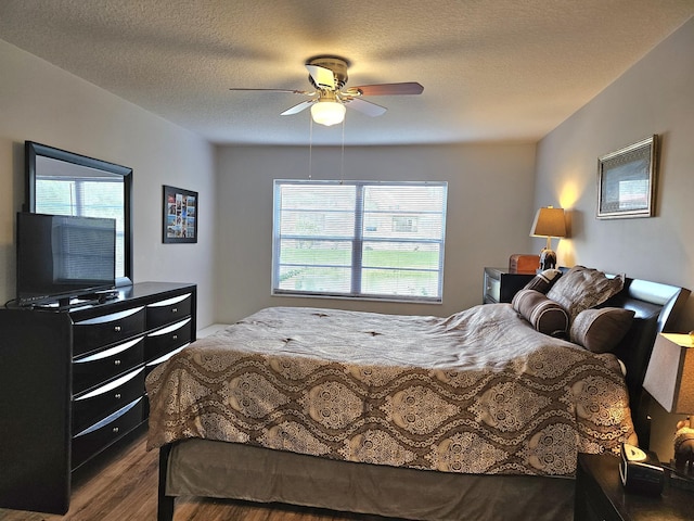 bedroom with ceiling fan, wood-type flooring, and a textured ceiling