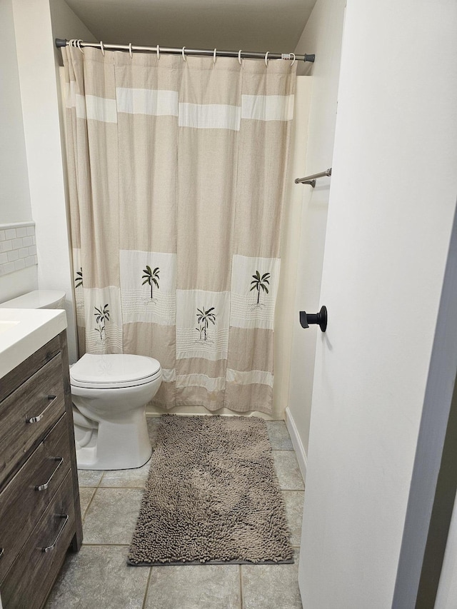 bathroom featuring tile patterned flooring, vanity, and toilet