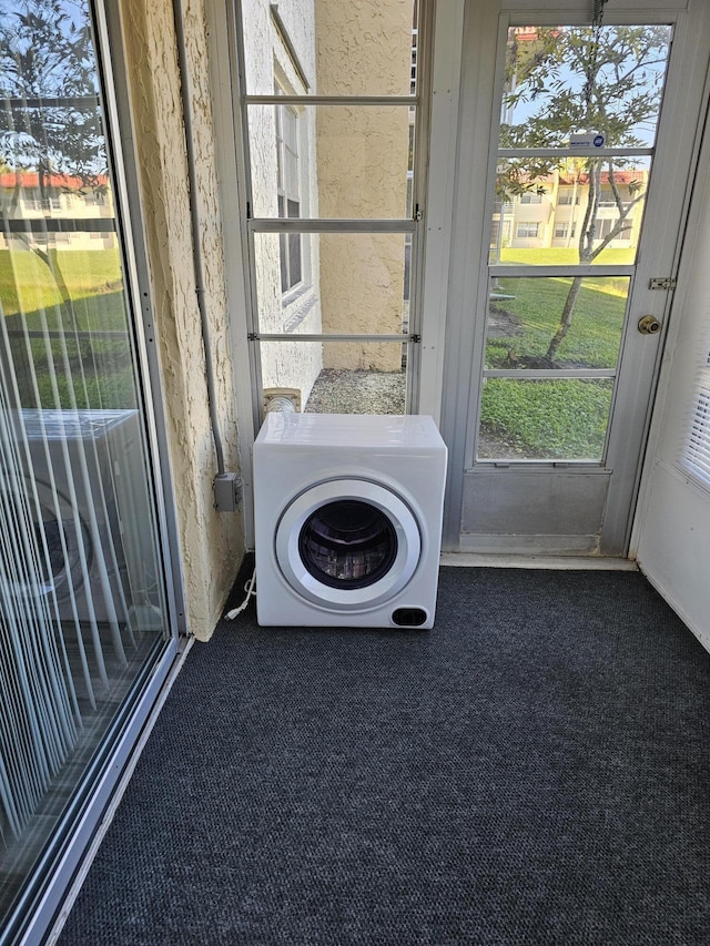 laundry room with dark colored carpet and washer / clothes dryer