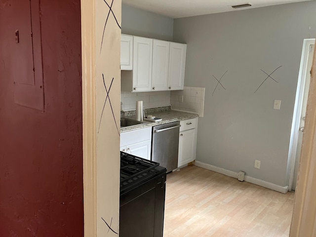 kitchen with decorative backsplash, dishwasher, white cabinets, and black range