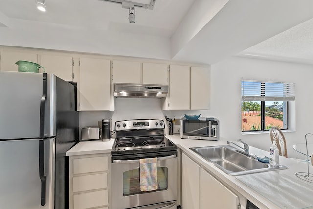 kitchen featuring sink, appliances with stainless steel finishes, and track lighting