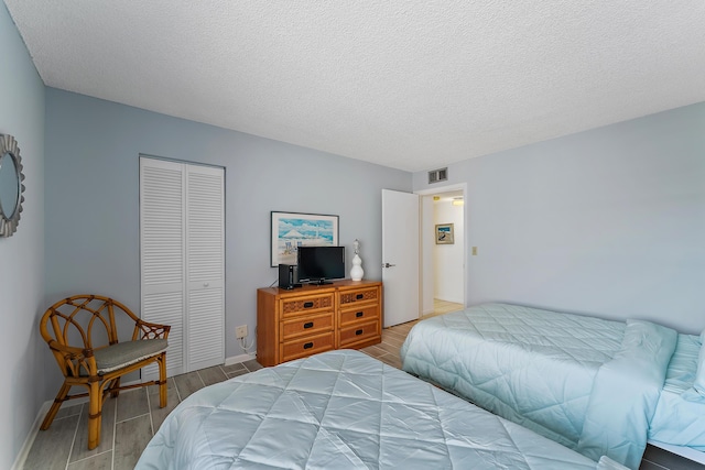 bedroom with a textured ceiling and a closet