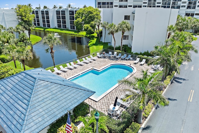 view of pool with a water view and a patio