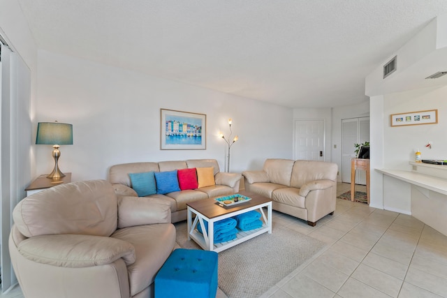 living room featuring light tile patterned floors and a textured ceiling