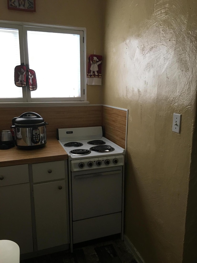 kitchen with electric stove and butcher block countertops