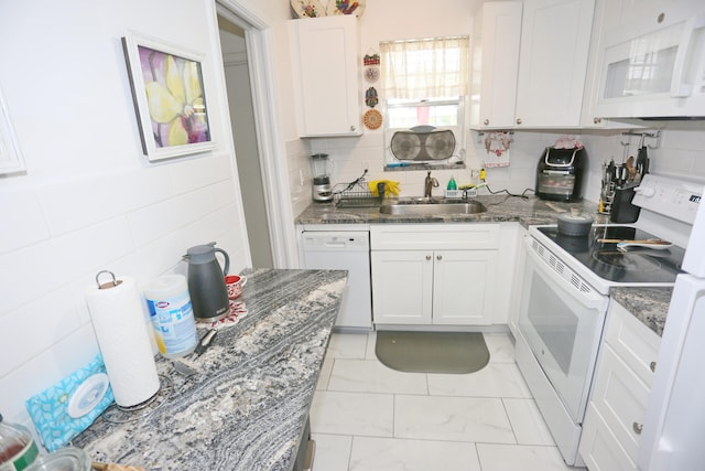 kitchen featuring white cabinetry, sink, tasteful backsplash, dark stone countertops, and white appliances