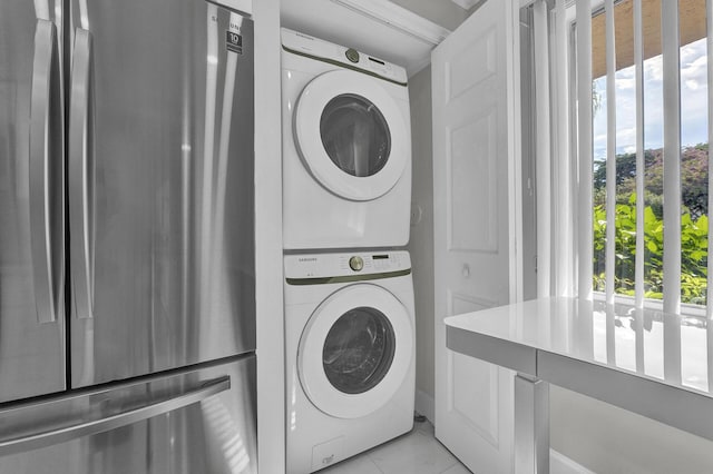 washroom with plenty of natural light, stacked washer / drying machine, and light tile patterned flooring