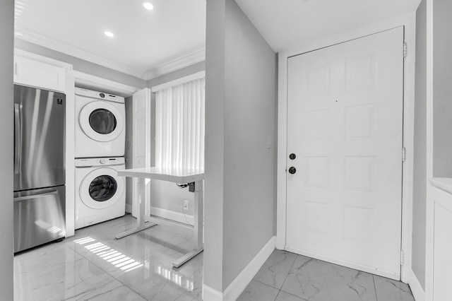 washroom with crown molding and stacked washer and clothes dryer