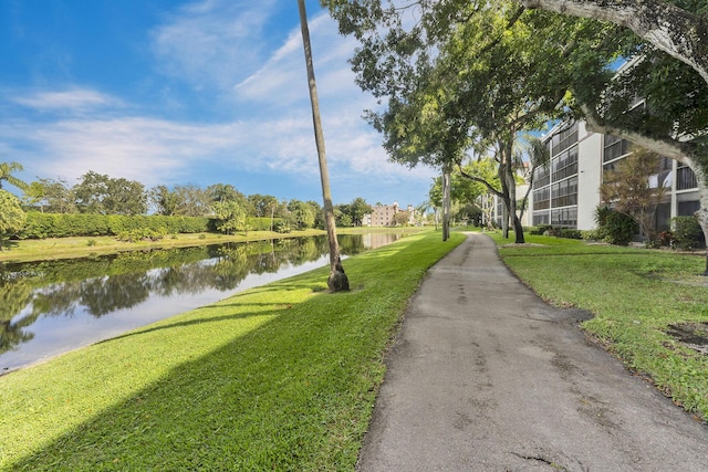 view of property's community with a water view and a yard