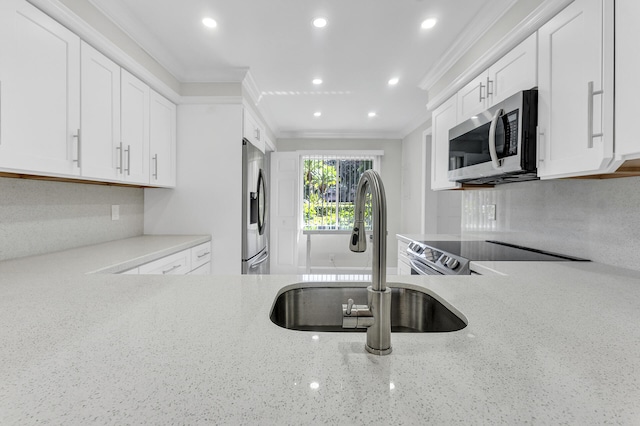 kitchen with white cabinetry, sink, stainless steel appliances, crown molding, and decorative backsplash