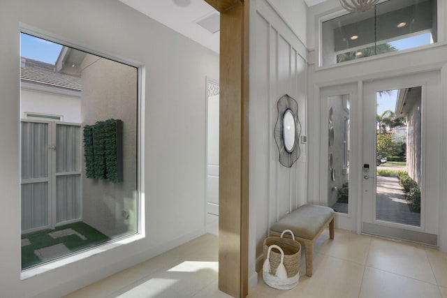 foyer entrance featuring light tile patterned floors and a wealth of natural light