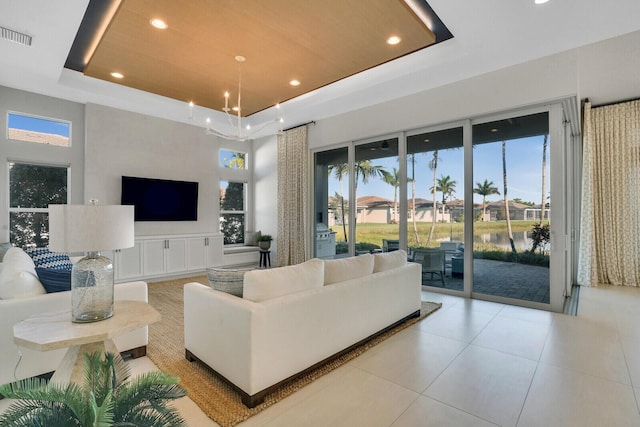 tiled living room with a tray ceiling, plenty of natural light, and a towering ceiling