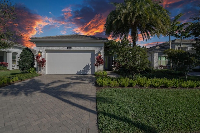 view of front of property with a garage and a yard