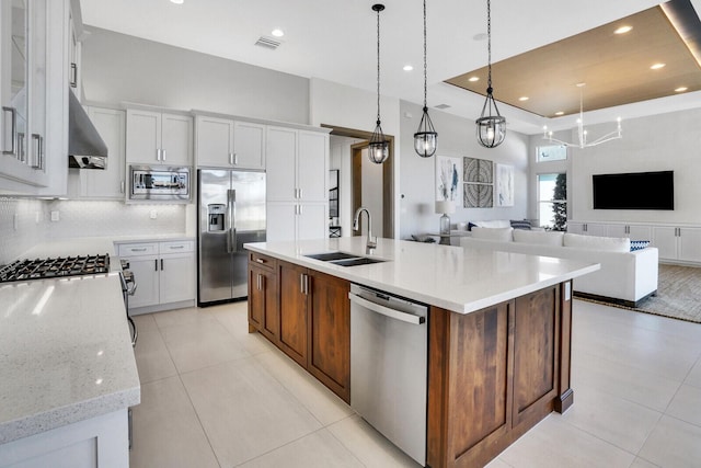 kitchen featuring a center island with sink, sink, white cabinetry, and stainless steel appliances