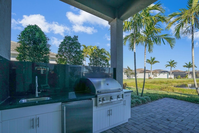 view of patio / terrace featuring area for grilling, sink, and an outdoor kitchen