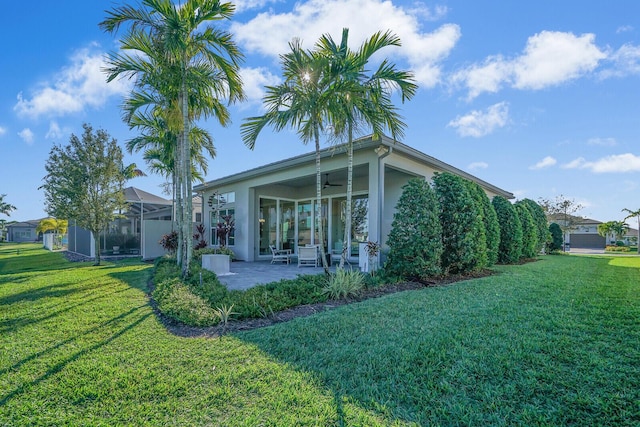 back of house with a yard, ceiling fan, and a patio area