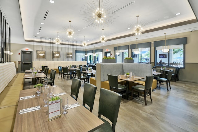 dining area with a tray ceiling and an inviting chandelier