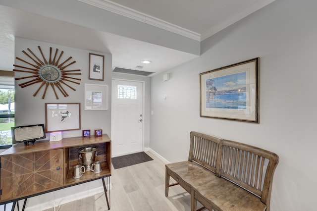 foyer entrance with ornamental molding, wood finished floors, and baseboards