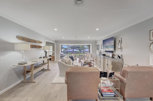 living room featuring light wood-style floors, baseboards, visible vents, and crown molding