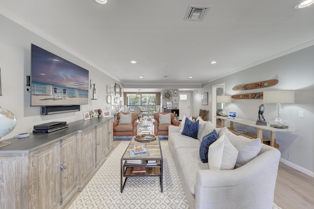 living area with ornamental molding, recessed lighting, visible vents, and light wood-style flooring