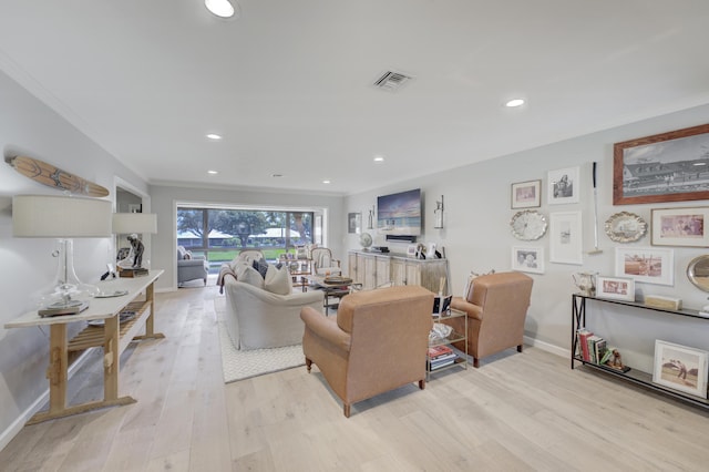 living room featuring ornamental molding and light hardwood / wood-style flooring