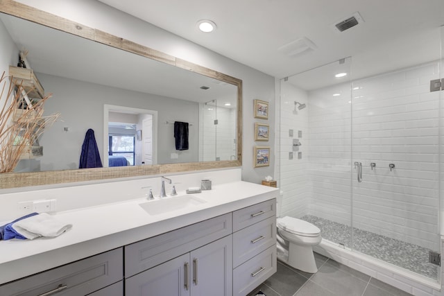 bathroom featuring tile patterned flooring, toilet, visible vents, vanity, and a stall shower