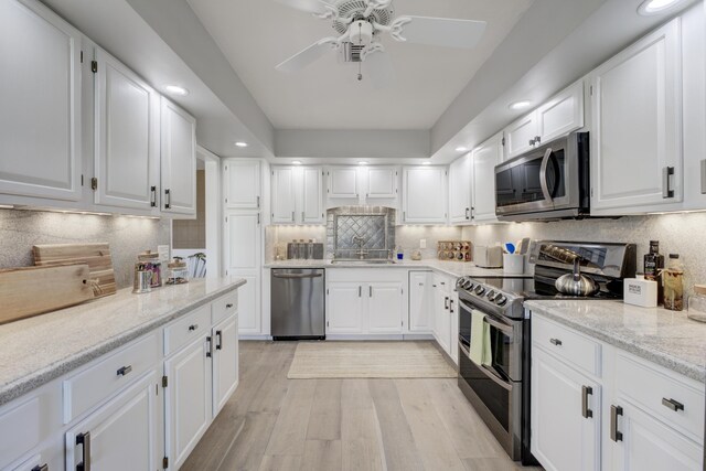 kitchen with white cabinetry, tasteful backsplash, stainless steel appliances, and ceiling fan