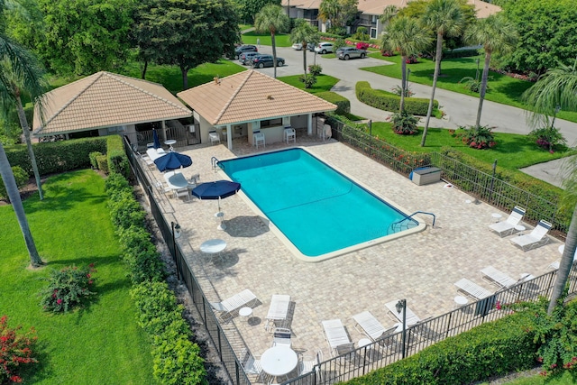 community pool featuring a fenced backyard, a lawn, and a patio