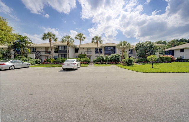 view of front of home featuring uncovered parking, a residential view, and a front lawn