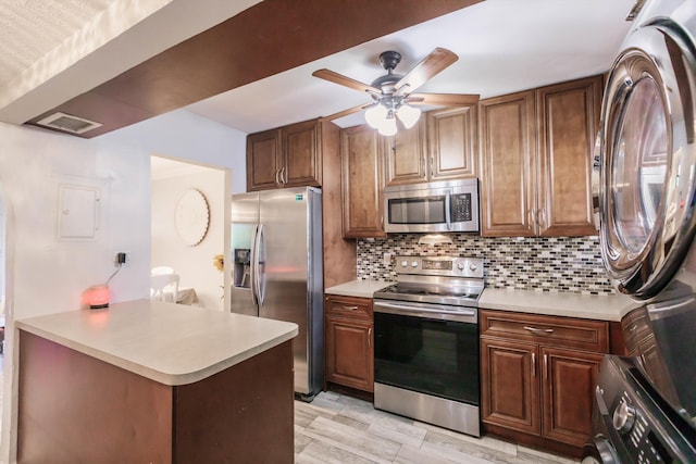 kitchen with tasteful backsplash, appliances with stainless steel finishes, and light countertops