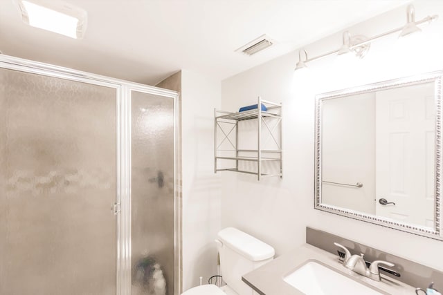 bathroom featuring vanity, toilet, visible vents, and a stall shower