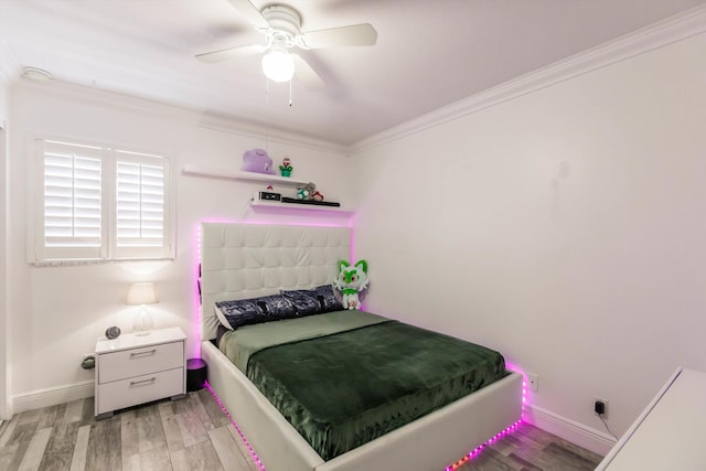 bedroom featuring a ceiling fan, light wood-style floors, baseboards, and ornamental molding